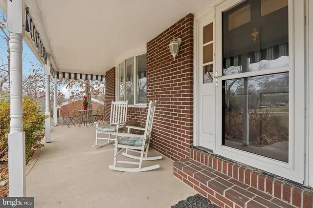 a balcony view with a couple of chairs and a potted plant