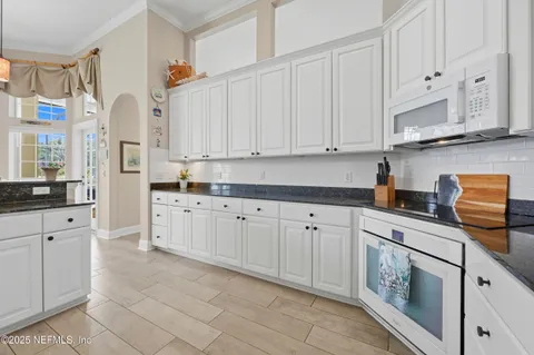 a kitchen with stainless steel appliances granite countertop white cabinets sink and dishwasher