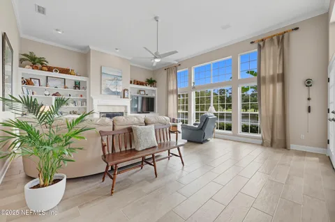a living room with furniture potted plant and a large window