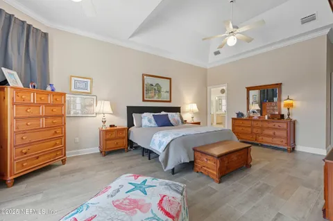 a spacious bedroom with a bed and a dresser