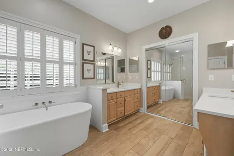 a spacious bathroom with a granite countertop tub sink and mirror