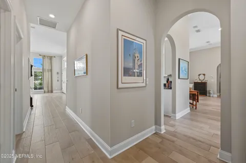 a view of a hallway with wooden floor and a living room