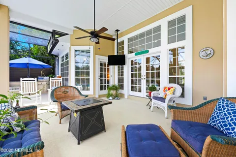 a living room with furniture and floor to ceiling windows