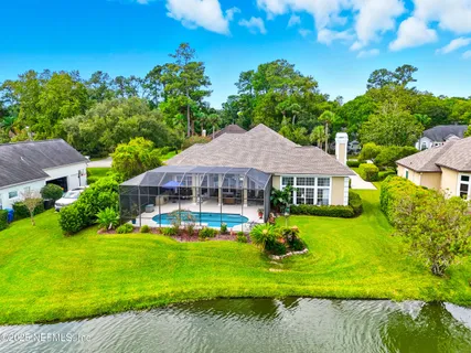 a view of a house with a yard table and chairs under an umbrella