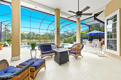 a living room with furniture a ceiling fan and a large window