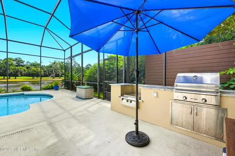 a view of a backyard with a table and chairs under an umbrella