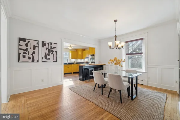 a kitchen with stainless steel appliances granite countertop a kitchen island a stove a sink dishwasher and white cabinets with wooden floor