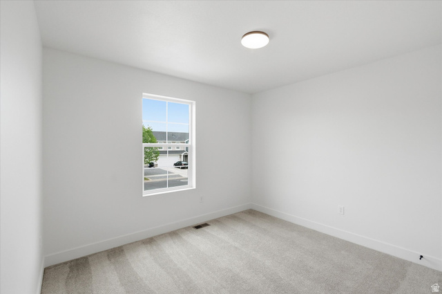 844 North 400 West Logan, UT 84321 - Photo 25 of 43 Bright room featuring a large single window, light-colored carpeting, white baseboards, and a flush-mount ceiling light