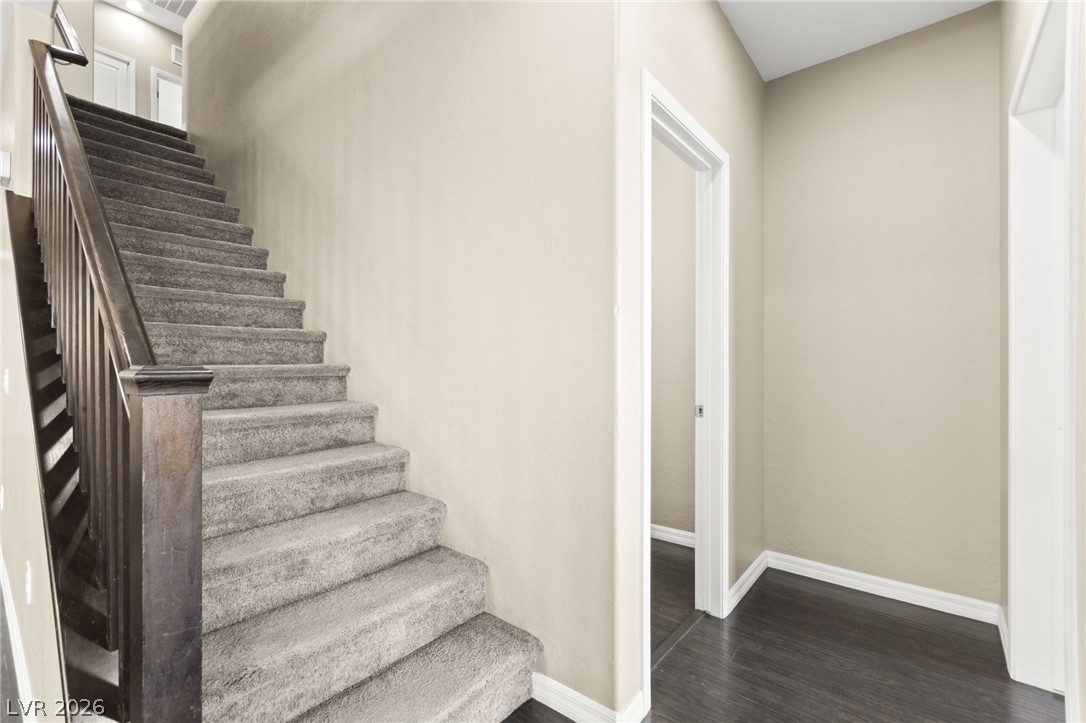 11048 Prairie Grove Road Las Vegas, NV 89179 - Photo 36 of 75 A grand staircase with dark wood railing welcomes you to this inviting home.