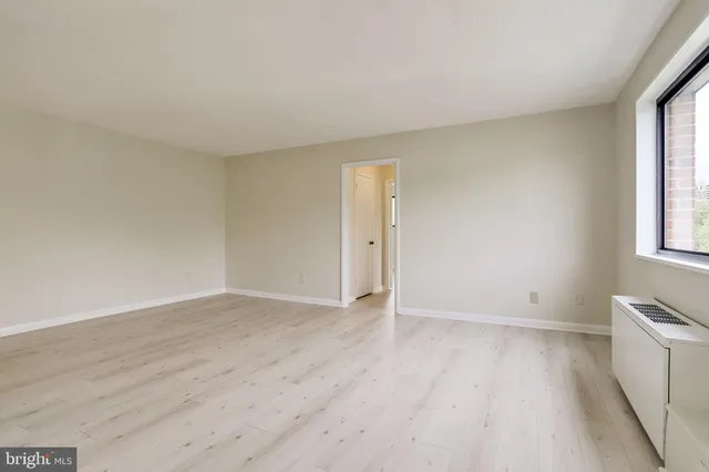a view of an empty room with wooden floor