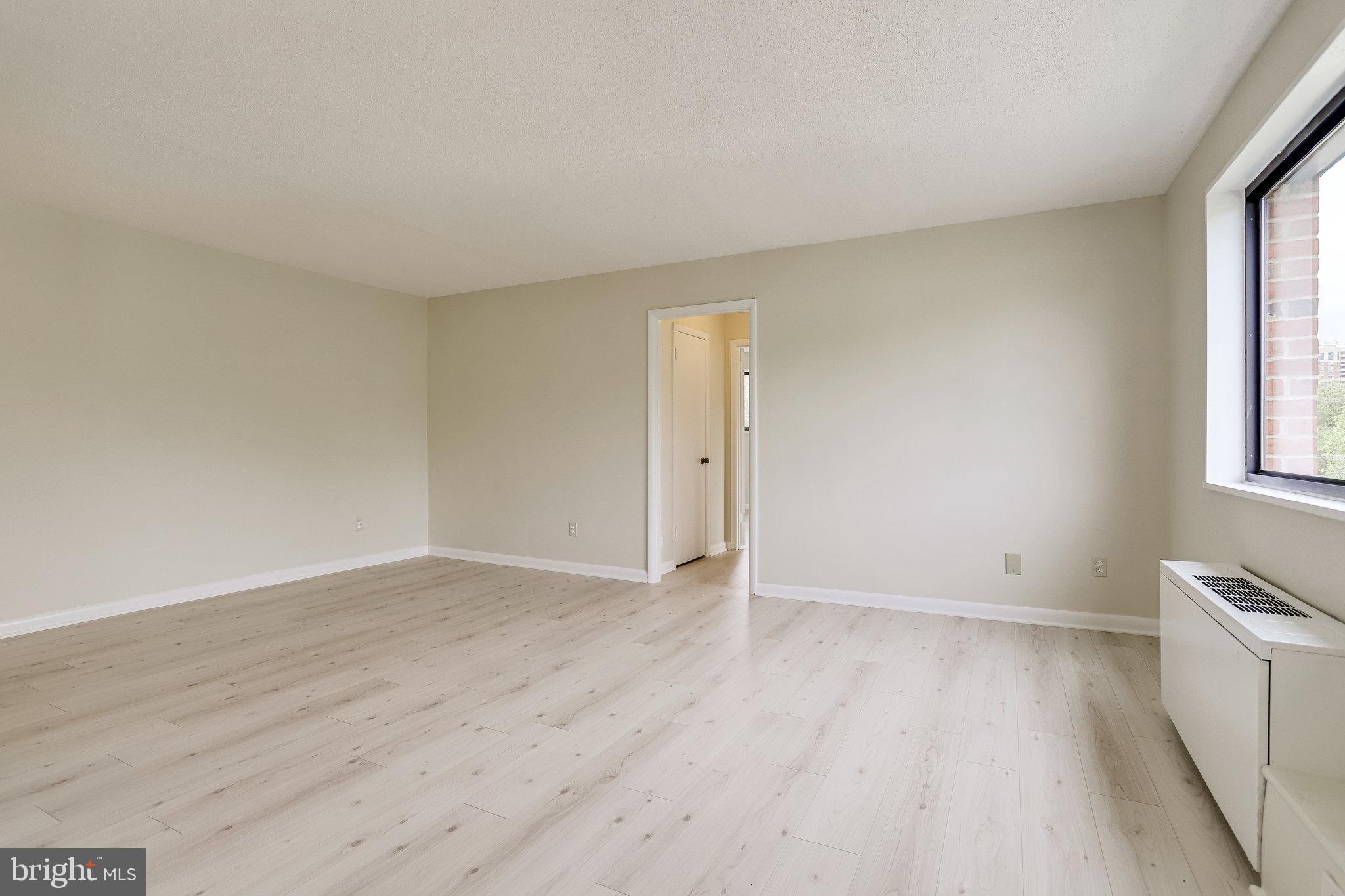 3515 Washington Boulevard, Unit 415 Arlington, VA 22201 - Photo 21 of 60 an empty room with wooden floor and windows