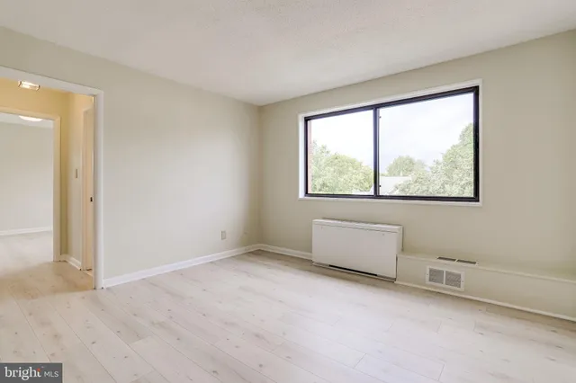an empty room with windows and closet