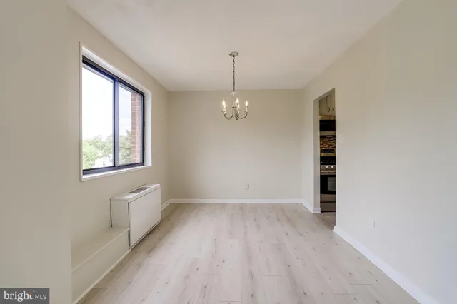 a view of empty room with wooden floor and window