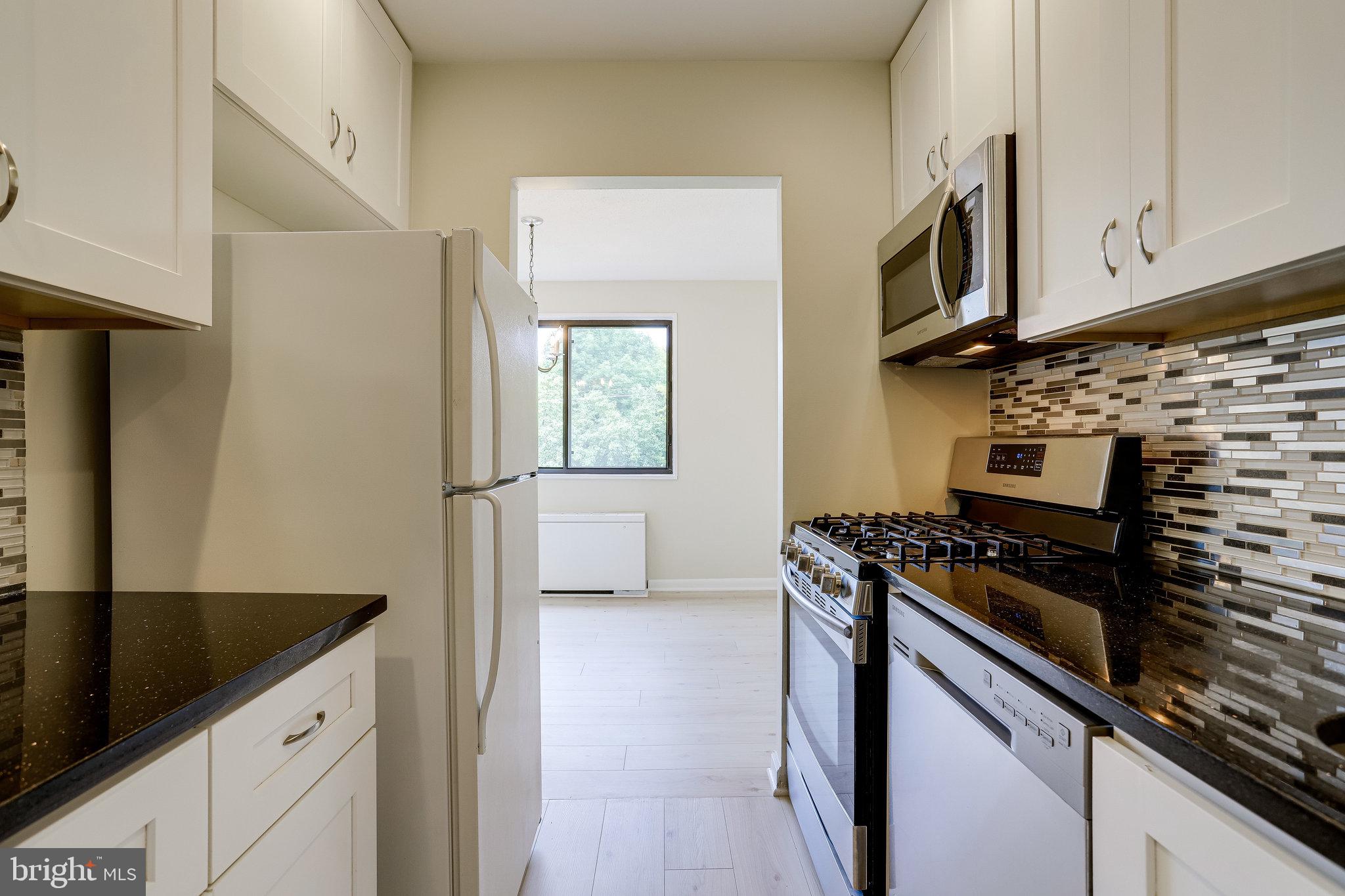 3515 Washington Boulevard, Unit 415 Arlington, VA 22201 - Photo 33 of 60 a kitchen with stainless steel appliances granite countertop a stove and a microwave