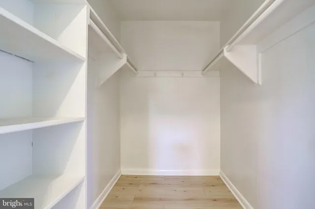 an empty room with windows and closet