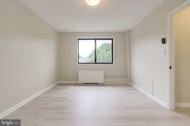 a view of an empty room with closet and a window