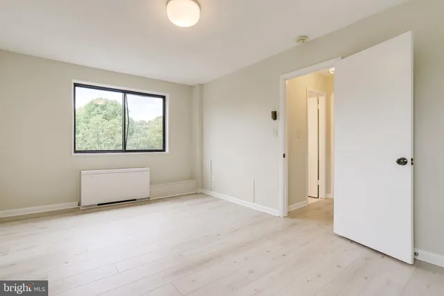 an empty room with windows and closet