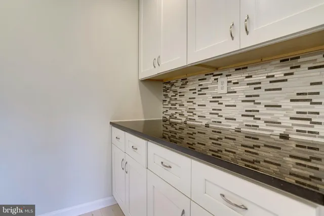 a kitchen with granite countertop a sink a stove and cabinets