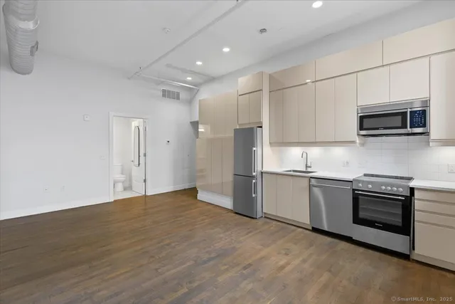 a kitchen with stainless steel appliances granite countertop a stove a sink and a refrigerator