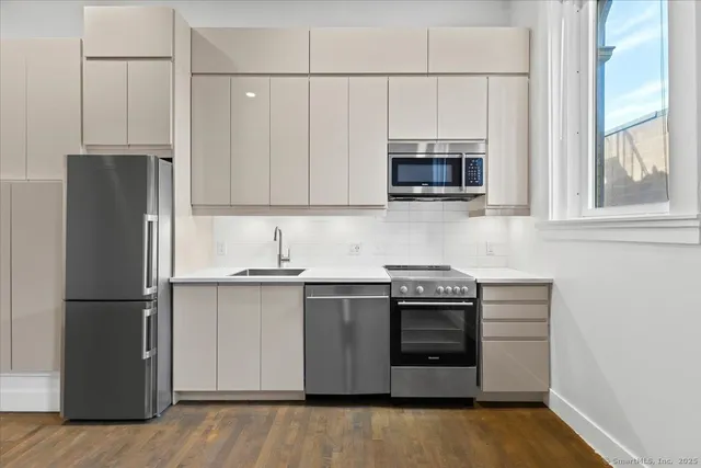 a kitchen with stainless steel appliances granite countertop a stove a refrigerator and a microwave