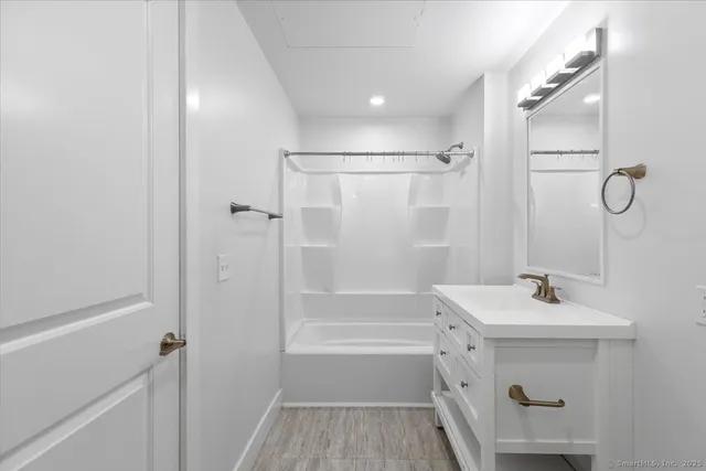a bathroom with a sink mirror shower and a bathtub