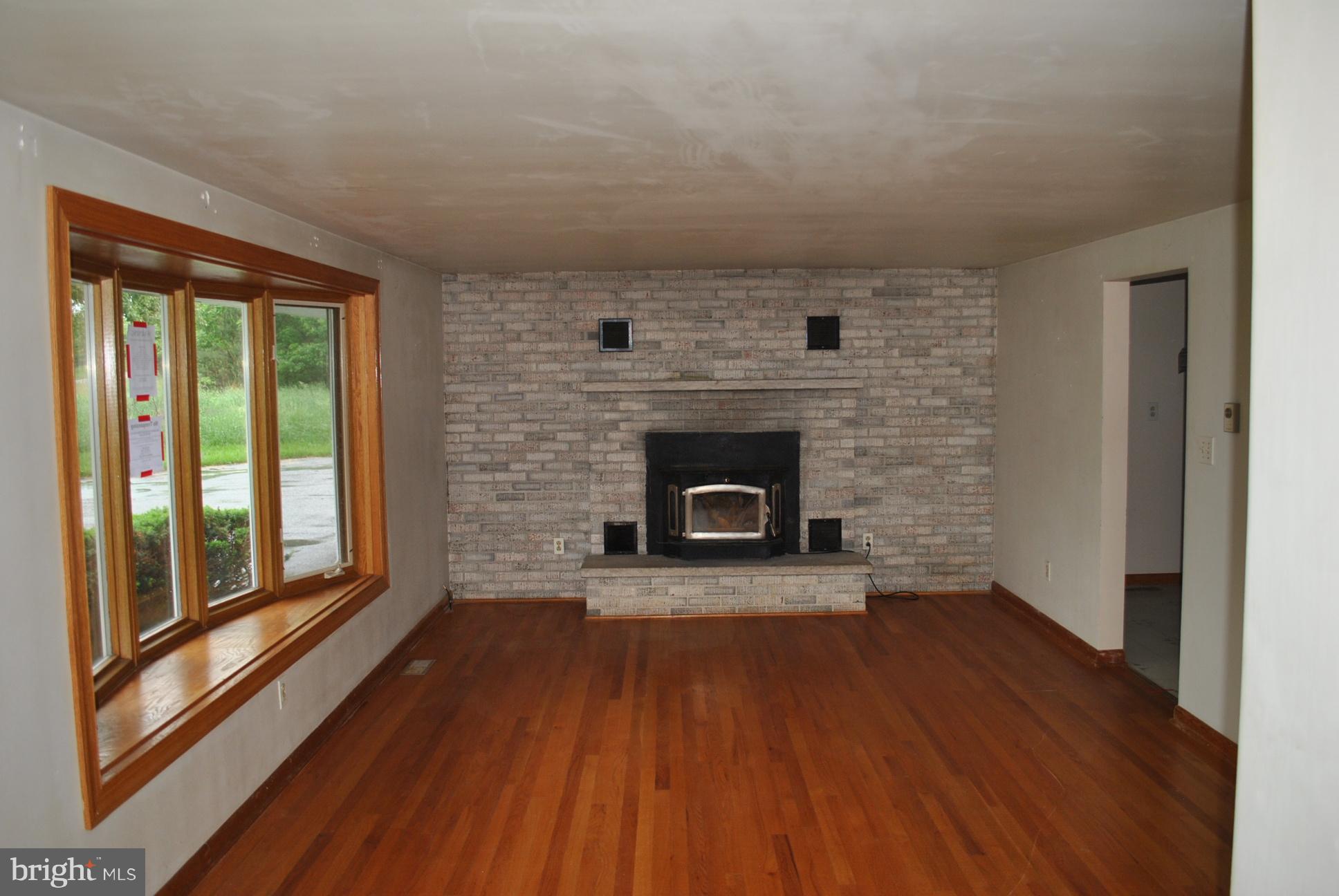 3803 Rockdale Road Manchester, MD 21102 - Photo 7 of 30 a living room with a fireplace and wooden floor