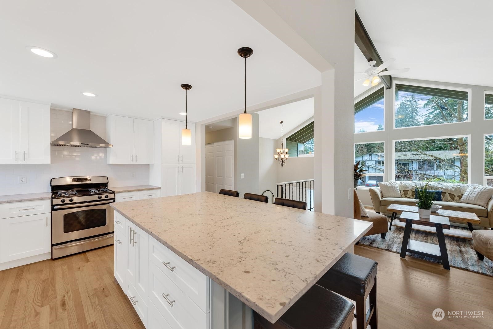2403 166th Place Southeast Bothell, WA 98012 - Photo 12 of 29 a kitchen with granite countertop a stove a sink a dining table and chairs with wooden floor