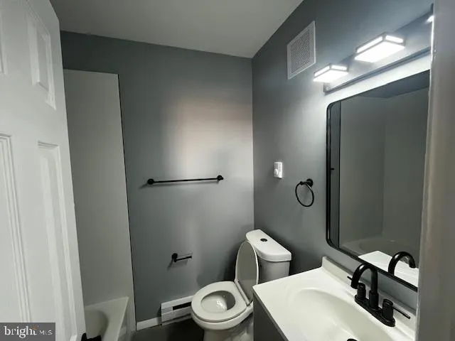 a white toilet sitting next to a bathroom sink