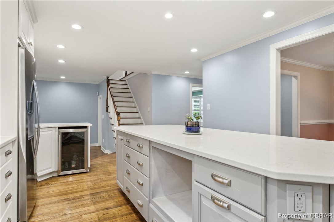 9300 Marlfield Road Gloucester, VA 23061 - Photo 21 of 50 Kitchen featuring crown molding, stainless steel refrigerator with ice dispenser, white cabinets, wine cooler, and light wood-type flooring