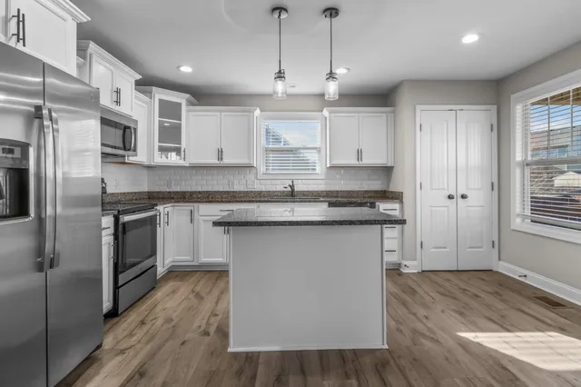 en empty room with windows and ceiling fan