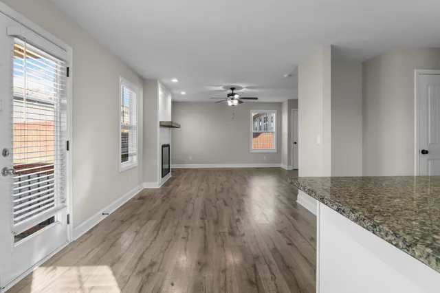 an empty room with a window and ceiling fan