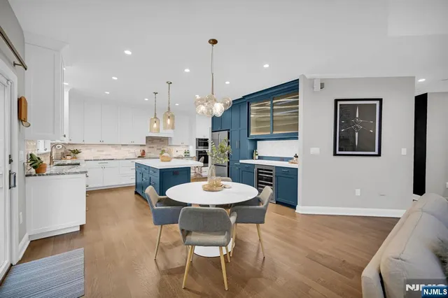 a kitchen with a dining table chairs and refrigerator