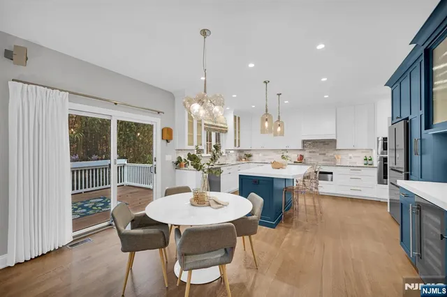 a kitchen with a dining table chairs and white cabinets