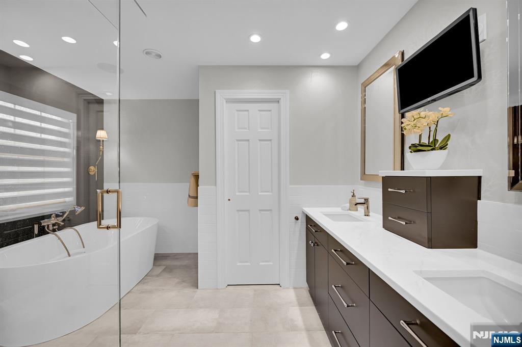 3 Brook Ridge Court Cedar Grove, NJ 07009 - Photo 27 of 49 a spacious bathroom with a double vanity sink a mirror and a bathtub