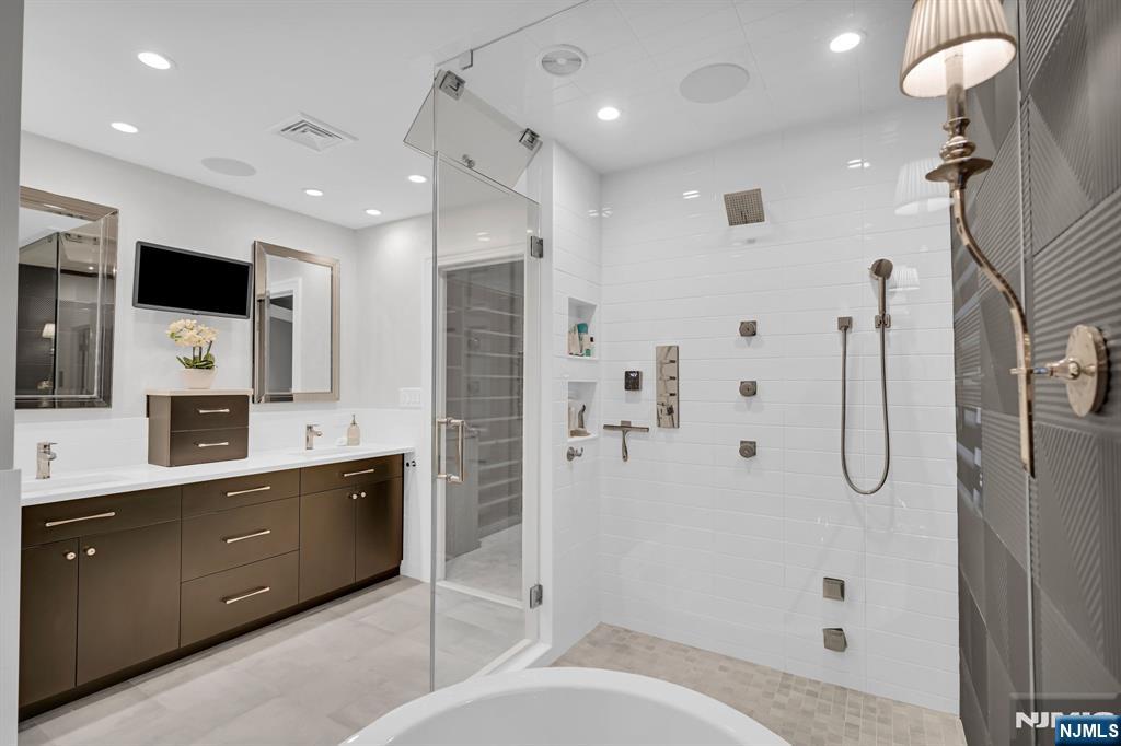3 Brook Ridge Court Cedar Grove, NJ 07009 - Photo 29 of 49 a bathroom with a double vanity sink a toilet a mirror and shower