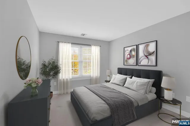 a bedroom with a bed and a painting on the wall