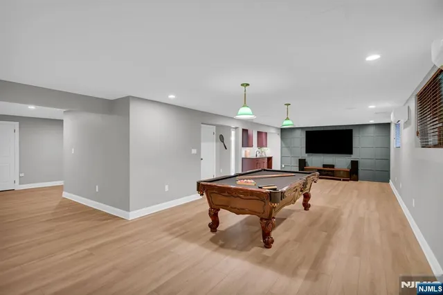 a living room with furniture pool table and a flat screen tv