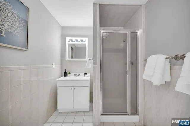 a bathroom with a sink and mirror with shower