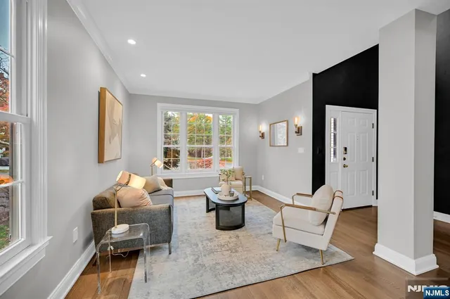 a living room with furniture and a flat screen tv with wooden floor