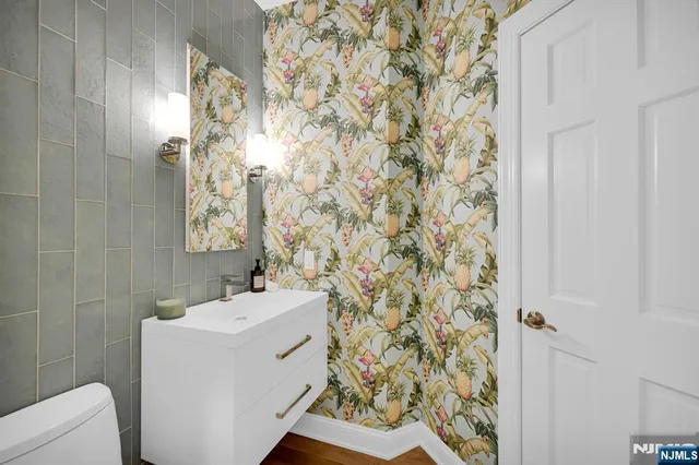 a bathroom with a sink and mirror with toilet