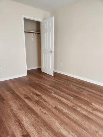 a view of empty room with wooden floor and entryway
