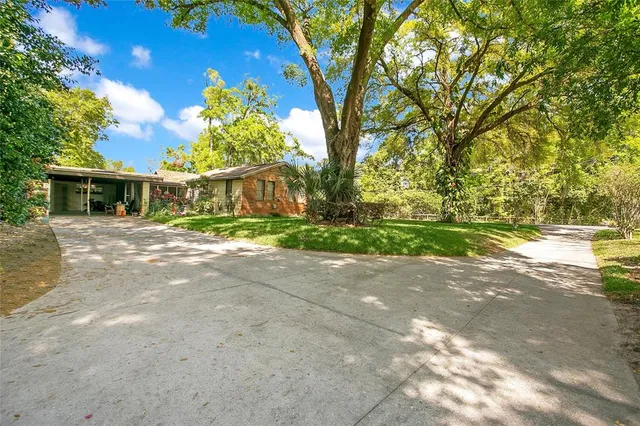 a view of a house with a yard and potted plants