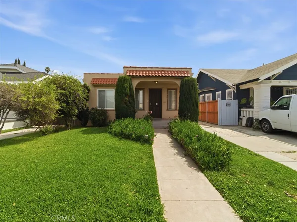 a front view of a house with a garden and plants