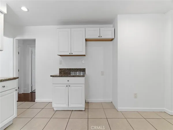 a kitchen with white cabinets a sink and a stove