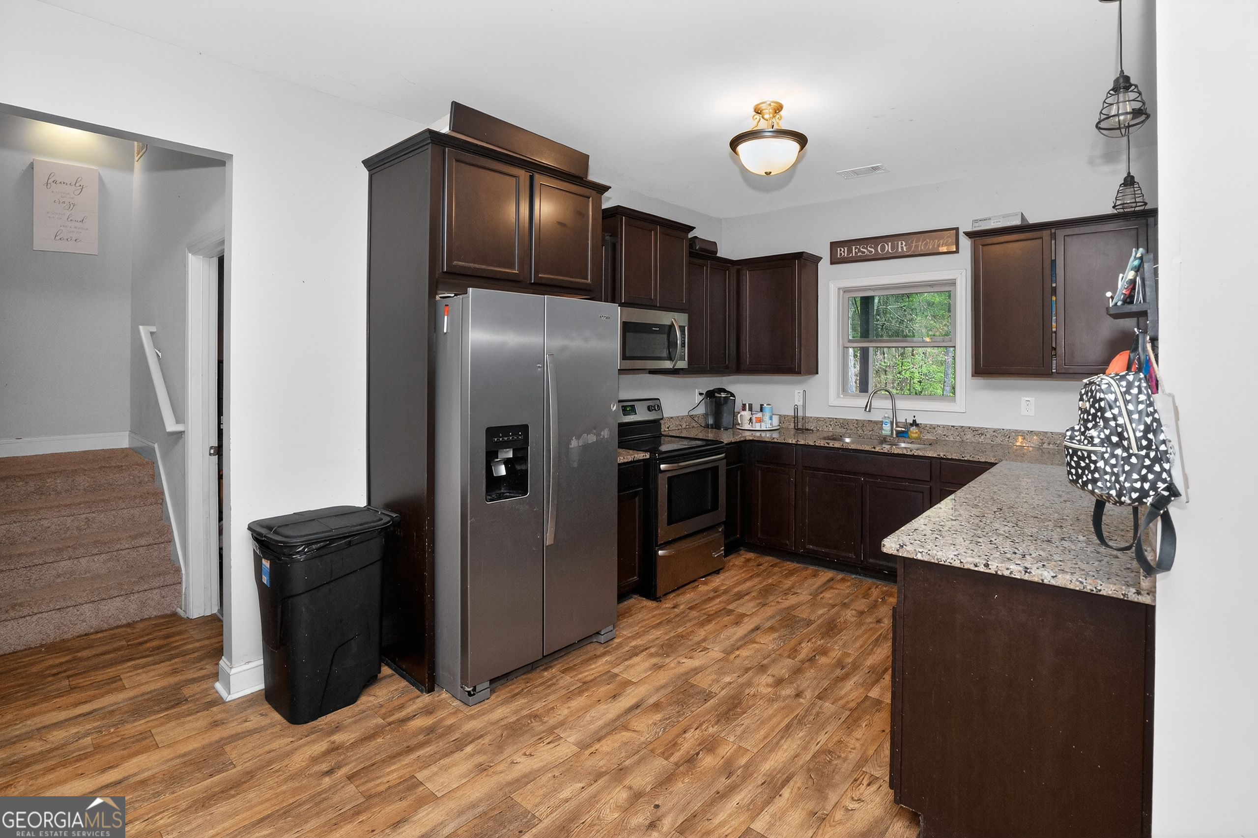 39 Crow Court Monticello, GA 31064 - Photo 19 of 39 a kitchen with stainless steel appliances granite countertop a refrigerator a sink a stove a microwave and wooden floors