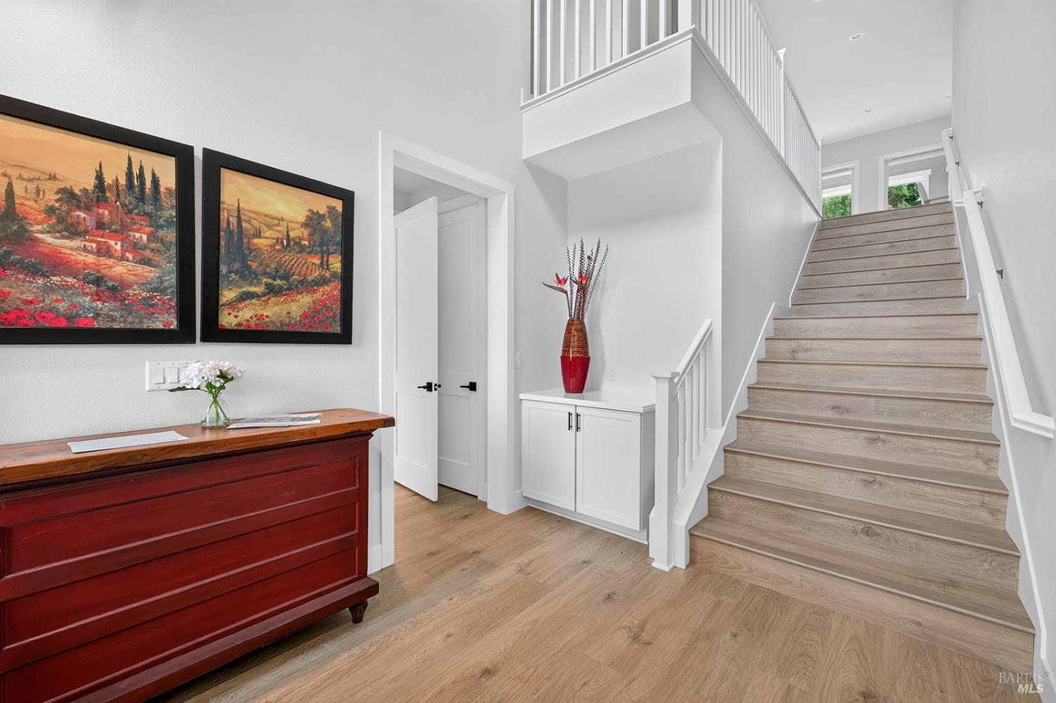 Here we are inside the front entrance. Interior entrance (behind the open entrance door is the coat closet) to the JADU is to the left with the wide stairs leading up to the main level. The entrance to the oversized 2-car garage is to the right of this photo.