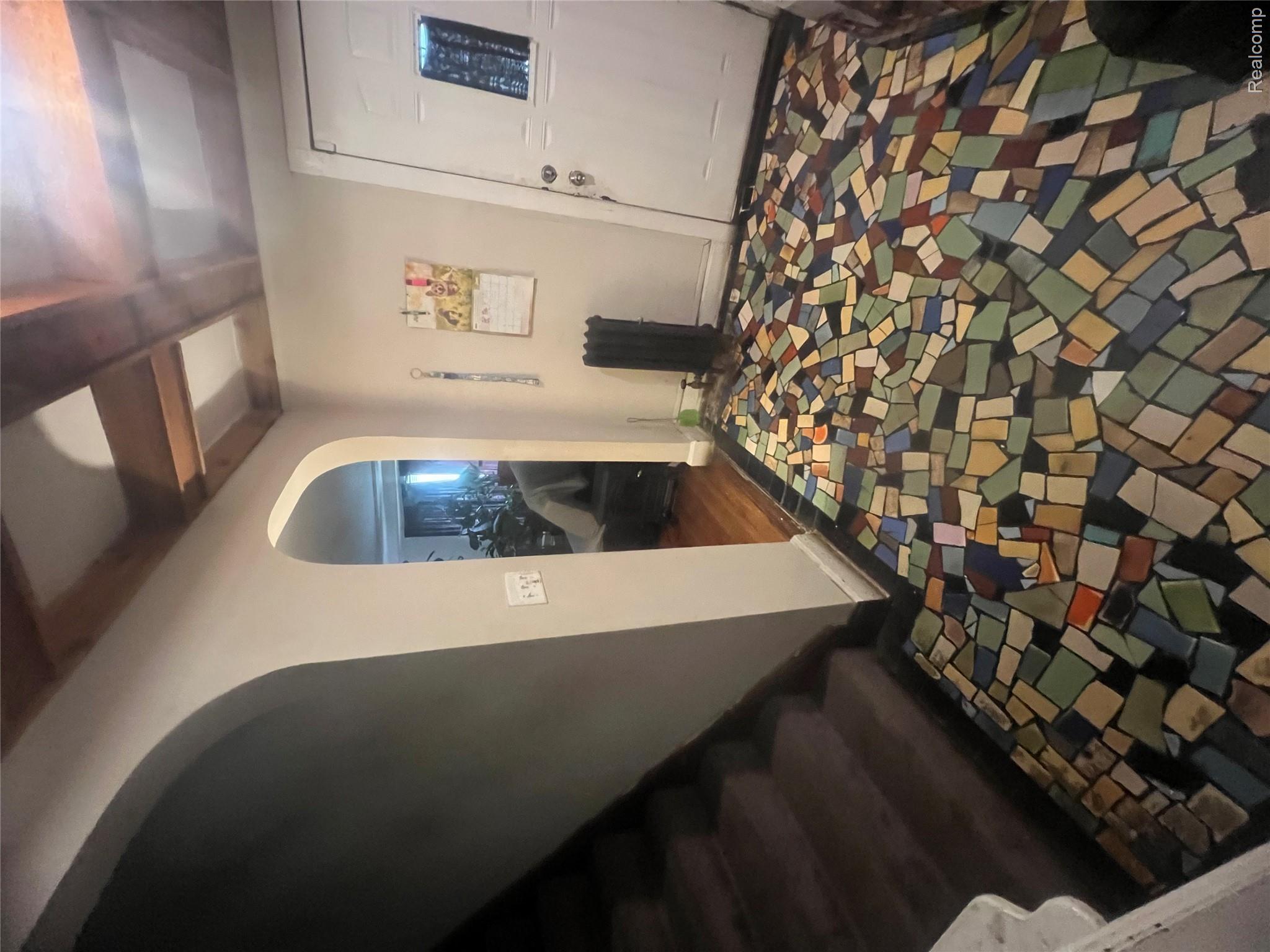17311 Santa Rosa Drive Detroit, MI 48221 - Photo 29 of 89 Mosaic tile flooring with varied geometric pieces, arched doorways, a coffered ceiling, and carpeted stairs