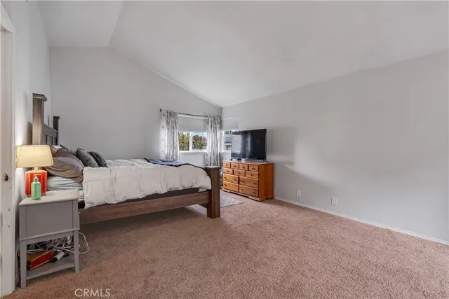 a spacious bedroom with a bed and a tv