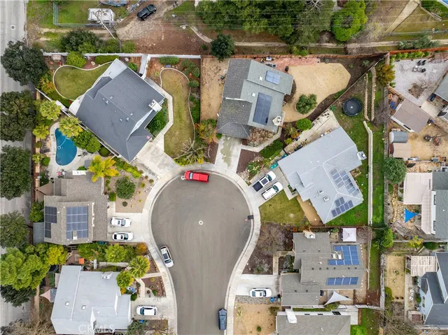 an aerial view of residential houses with outdoor space and parking