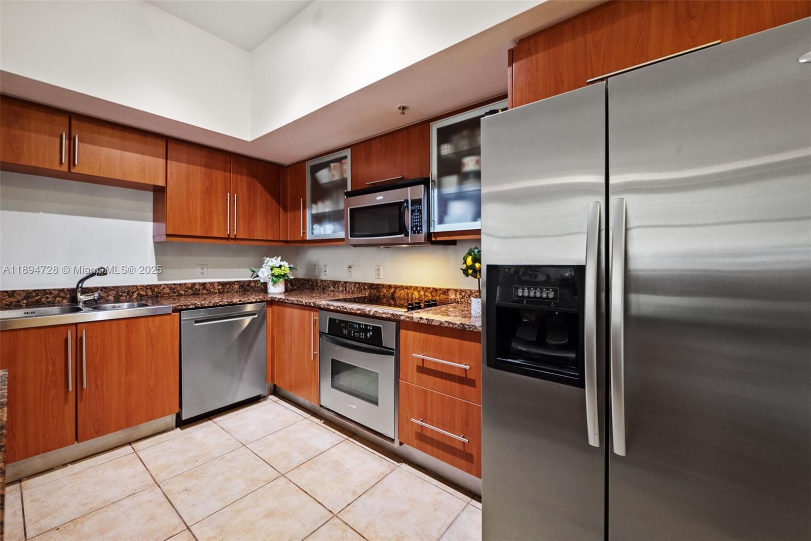 888 Douglas Road, Unit 113 Coral Gables, FL 33134 - Photo 20 of 40 a kitchen with stainless steel appliances granite countertop a refrigerator and a sink